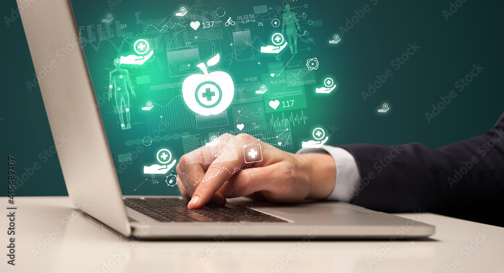 hand browsing on the internet for medical issues with healthy apple icons coming out from the screen hand browsing on the internet for medical issues with healthy apple icons coming out from the screen