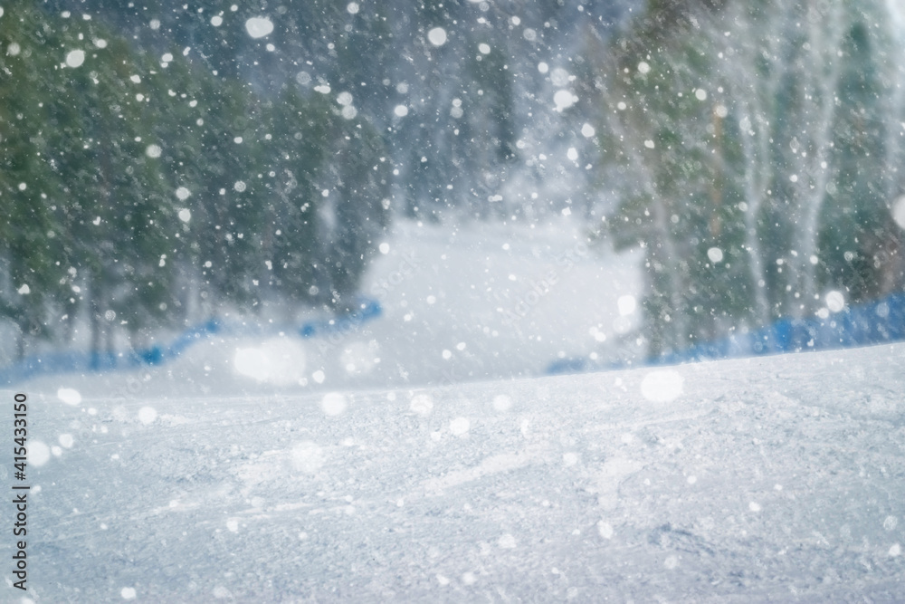 Beautiful winter blurred background of ski slope with falling snow Beautiful winter blurred background of ski slope with falling snow