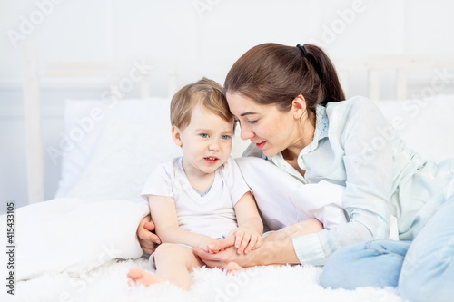 mom and baby talking at home on the bed, the concept of the relationship between parents and children