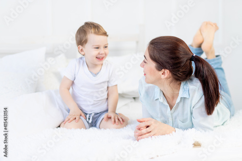 mom and baby talking at home on the bed, the concept of the relationship between parents and children