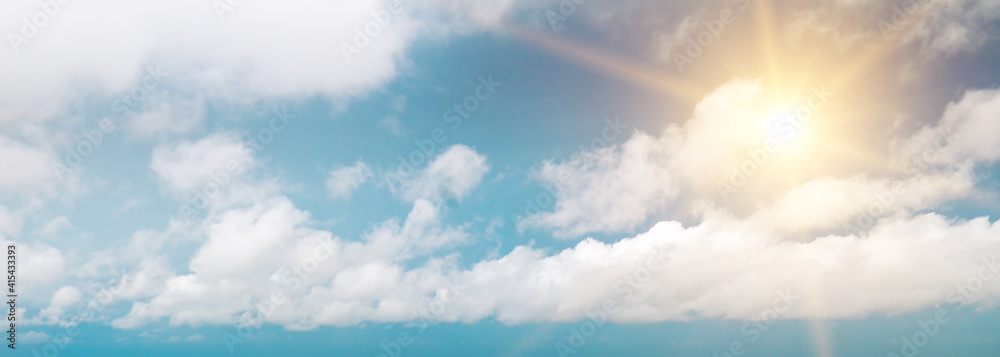 Fototapeta premium Strong sun, blue sky and clouds. Wide photo.