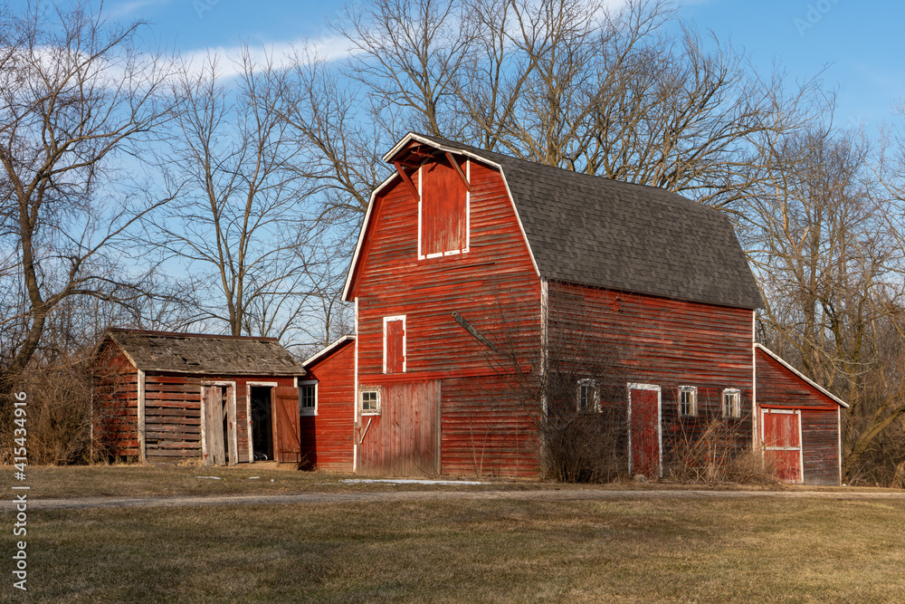 A tall, wooden three-story barn with white trim, and a very small corn crib. A tall, wooden three-story barn with white trim, and a very small corn crib.