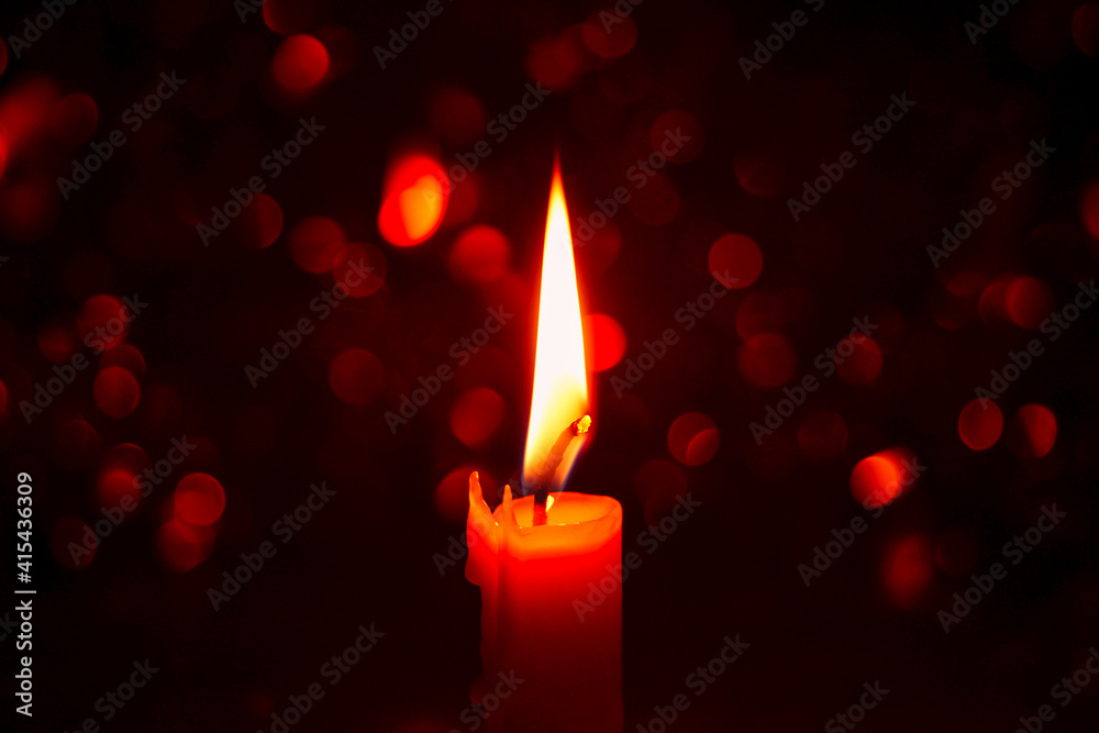 Candle light with festive bokeh on black background Holiday and religious ideas.
Candle light with festive bokeh on black background Holiday and religious ideas.
