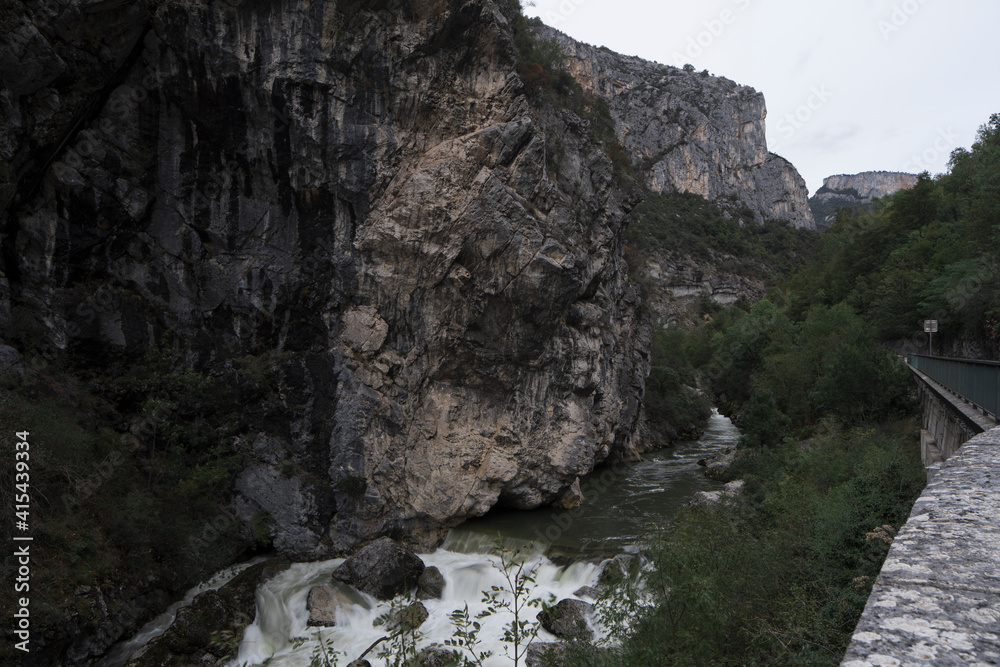 View along the river of the rocks in Pont-en-Royans, in the Auvergne-Rhone-Alps region, during twilight of a winter day.