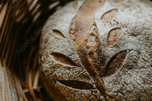 Traditional handmade, homemade sourdough bread in the basket, wooden background, blue teatowel photo