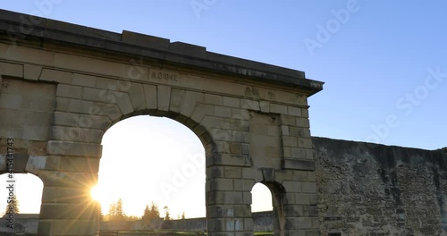 Slight top to bottom tilt pan of the brick walls and ruins of the Penal Colony prison at kingston at morning sunrise, Mostly just surrounding walls remain, Kingston, Norfolk Island,Australia photo