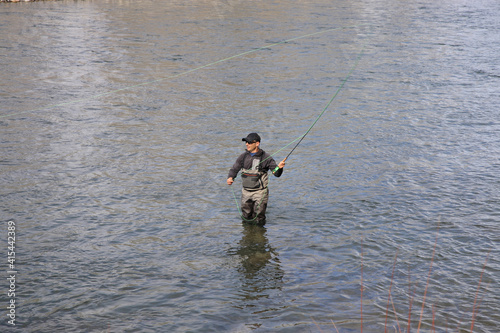 Fly fisherman hooking into a steelhead trout on the Salmon River in Idaho, USA