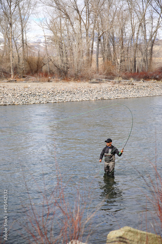 Fly fisherman hooking into a steelhead trout on the Salmon River in Idaho, USA