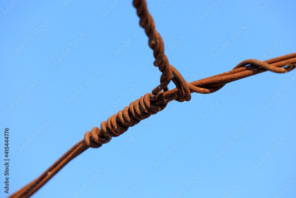 Oxidized and rusty wire against a blue background