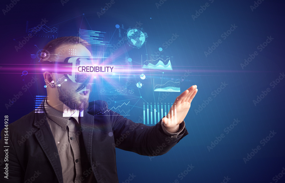 Businessman looking through Virtual Reality glasses with CREDIBILITY inscription, new business concept