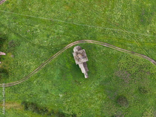 A wooden abandoned temple in the village of Rakula. Temple in the middle of the field. Russia, Arkhangelsk region, Kholmogorsky district  photo