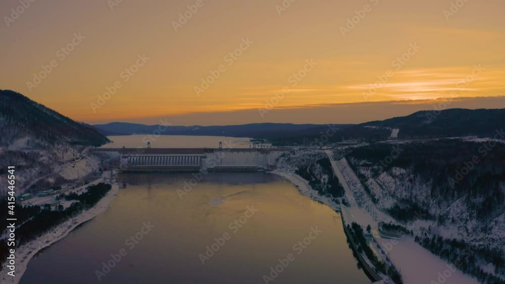 View of the dam of a hydroelectric power station, in Siberia on the river in winter View of the dam of a hydroelectric power station, in Siberia on the river in winter
