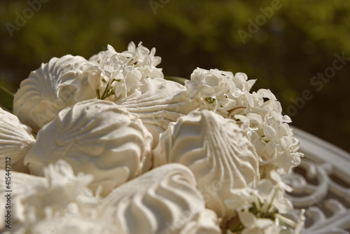 Sweet marshmallows and white lilac flowers on the vintage table creates bright spring mood