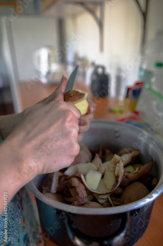 hands with knife peeling potatoes