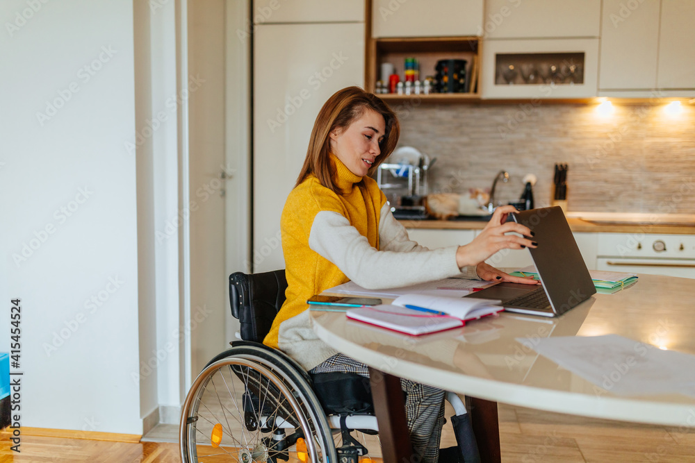 Φωτογραφία Woman sitting in her wheelchair while working at home