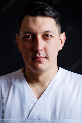 Close-up portrait of a young male doctor in medical clothes.