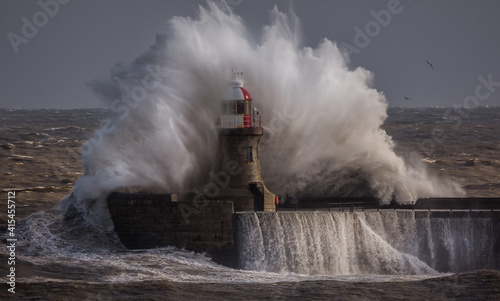 Giant waves batter the 15metre tall lighthouse which guards the south pier at the mouth of the Tyne at South Shields, England photo