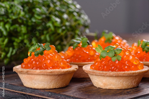 Delicious fresh red caviar on a dark concrete table