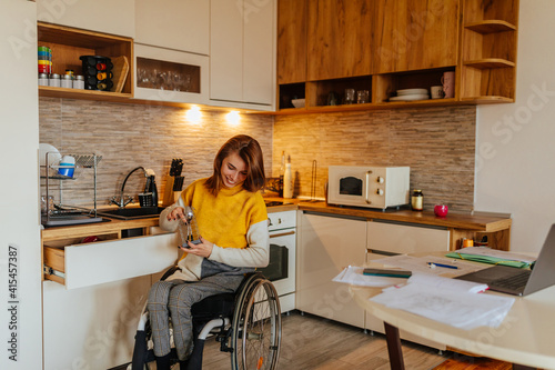 Woman in a wheelchair with her cat in the kitchen