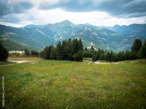 Cumbres de los Pirineos en Andorra, con prados, bosques y altas montañas que se recortan en el cielo con nubes