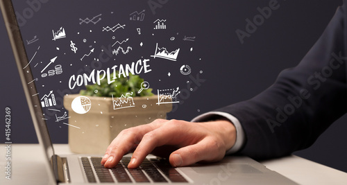 Businessman working on laptop with COMPLIANCE inscription, modern business concept
