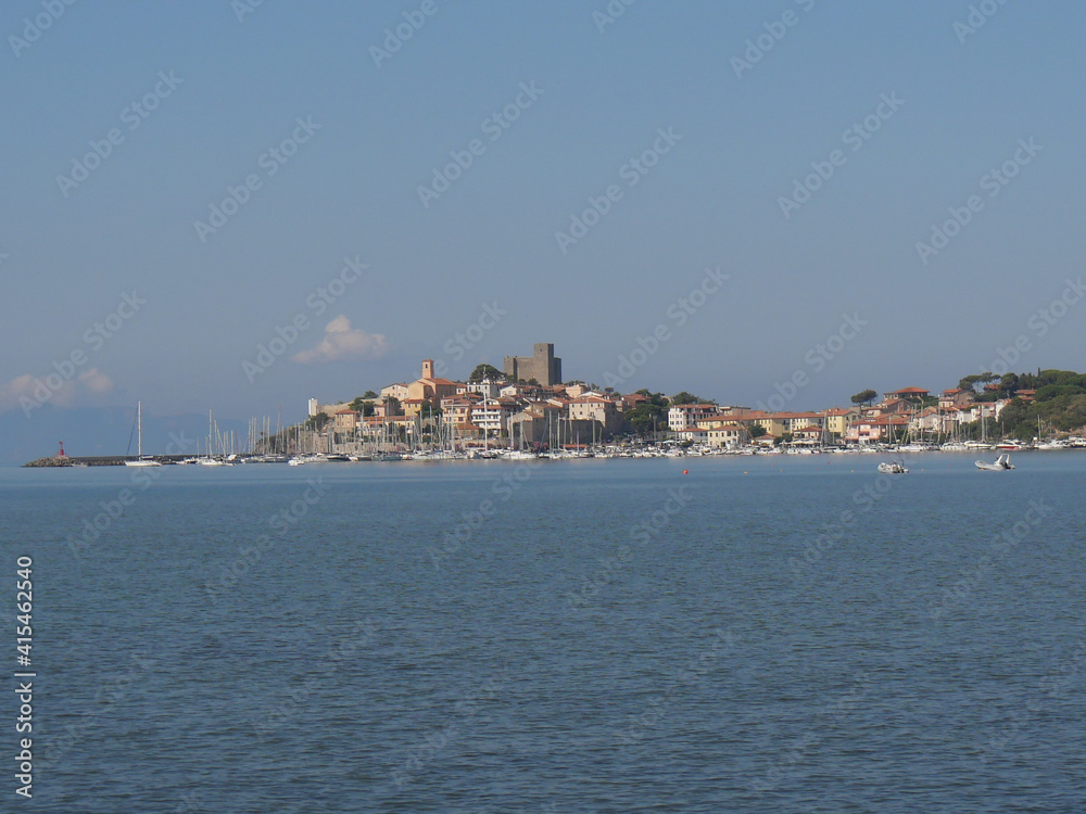 Panorama of the fortified medieval village of Talamone and of its coast lapped by the Tyrrhenian Sea.