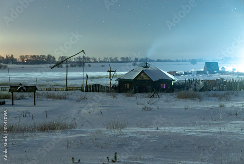 Ukrainian snow-covered country house. Winter night. Starry night sky.