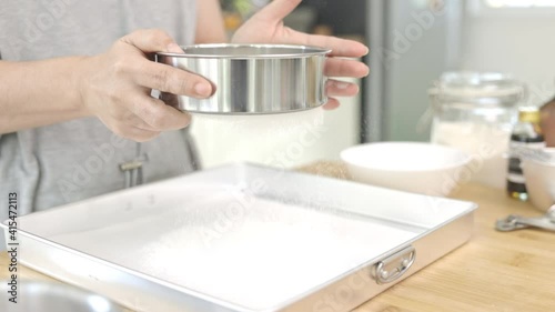 Close up female hand Sift the flour to make cakes, slow motion.