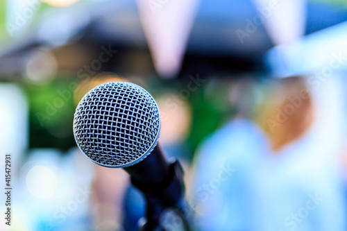 Microphone or mic for a vocal singer or commercial announcer on a professional tripod for best sound and mix process on a colorful blurry background