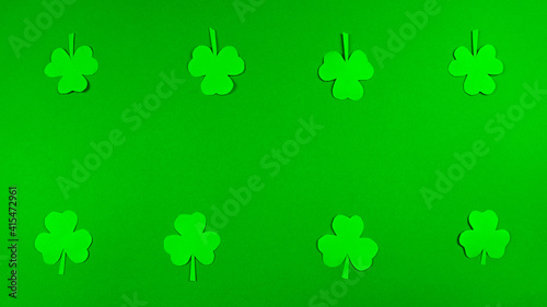 Greeting card for St. Patrick's Day, which is celebrated on March 17. Irish cultural holiday. Symbols of feast a shamrocks. Green background.