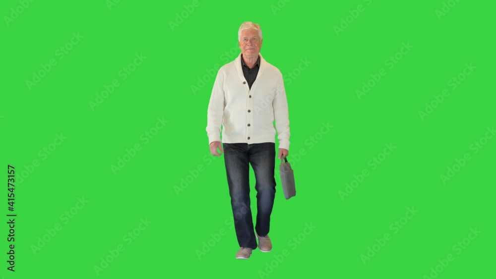 Senior grey-haired businessman walking with a briefcase on a Green Screen, Chroma Key. Senior grey-haired businessman walking with a briefcase on a Green Screen, Chroma Key.
