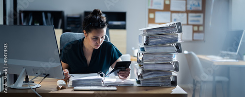 Young Businesswoman Working At Office With Stack Of Folders photo