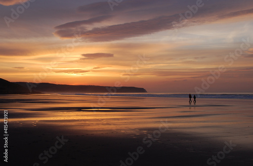 Couple walking on beach at Sunset  Whitby