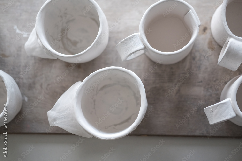 White handmade clay cups. Tea set on the table. White kitchen items White handmade clay cups. Tea set on the table. White kitchen items