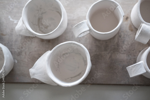 White handmade clay cups. Tea set on the table. White kitchen items