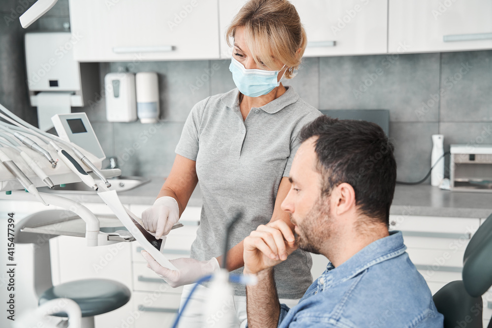 Fototapeta premium Doctor showing a patient his x ray after procedures