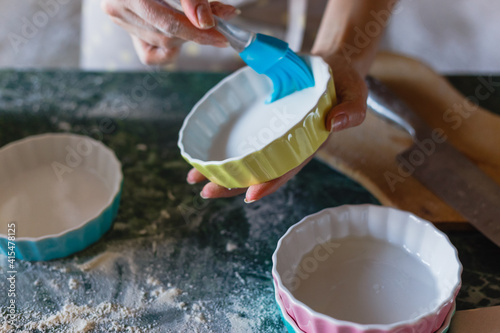 Woman greasing baking mould before adding batter