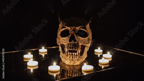 Teschio illuminato da candele con sfondo nero