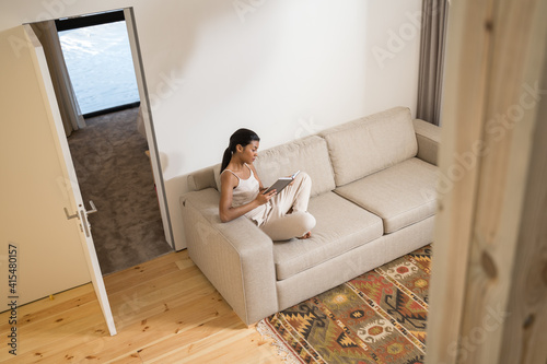 Woman sitting and relaxing on sofa in living room