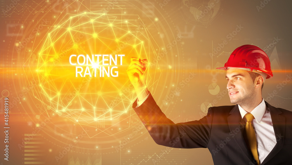Handsome businessman with helmet drawing CONTENT RATING inscription, social construction concept Handsome businessman with helmet drawing CONTENT RATING inscription, social construction concept