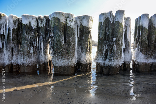 Fototapeta Naklejka Na Ścianę i Meble -  Iced groynes in early spring on the coast of the Baltic Sea in northern Germany