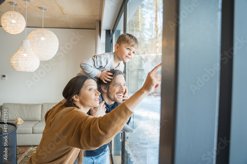 Woman showing at window something to her son