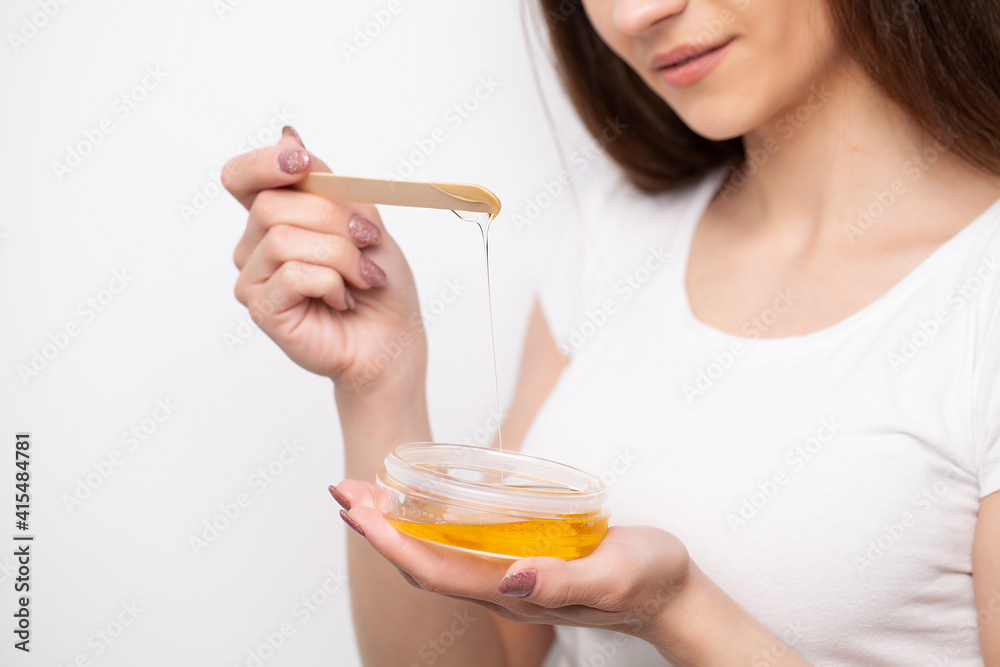 Close up women hold orange paraffin wax bowl. Close up women hold orange paraffin wax bowl.