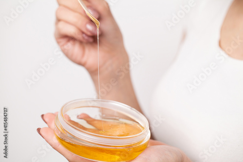 Fotografie Close up women hold orange paraffin wax bowl.