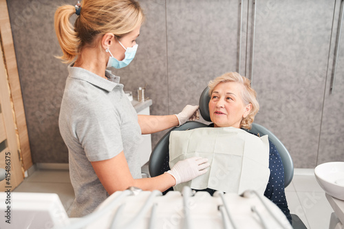Woman is sitting in dental chair in clinic