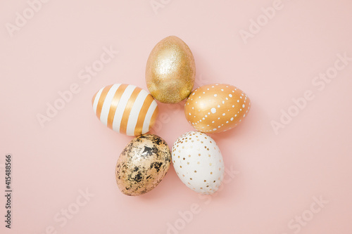 Easter golden decorated eggs on pastel pink background. Minimal easter concept. Happy Easter card with copy space for text. Top view, flatlay