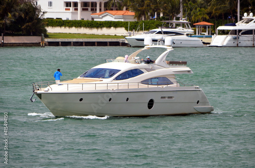 White motor yacht slowly cruising on Biscayne Bay off of Miami Beach,Florida