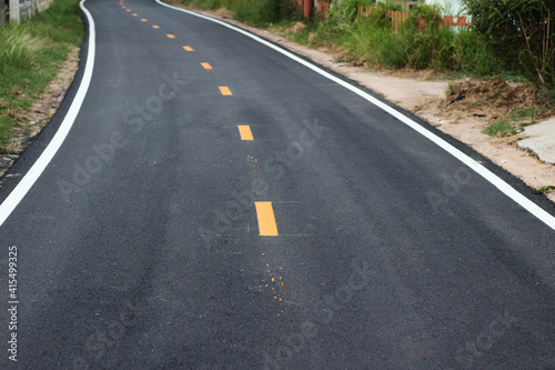 black asphalt winding road transport with white and yellow line