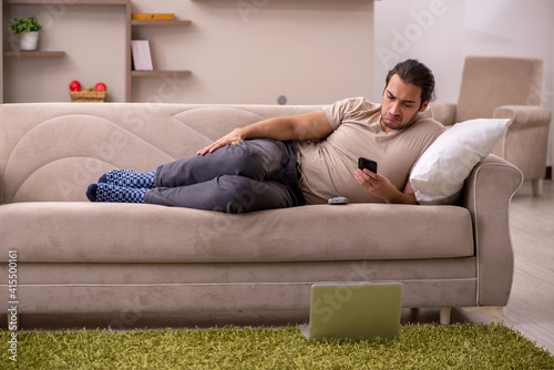 Young man lying on the sofa at home