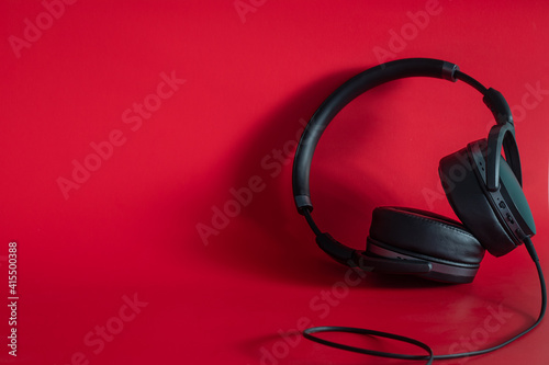 black headphones on red background with space